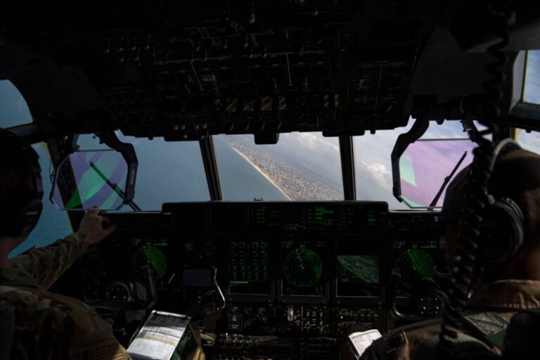AP reporters aboard a US military plane watch small batches of aid airdropped on a destroyed Gaza