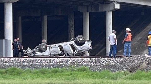 Driver hospitalized after losing control of vehicle, rolling it over on train tracks near Highway 90