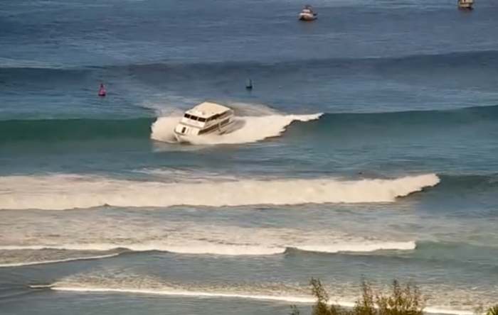Yacht-sized passenger boat runs aground in high surf off Hawaii beach
