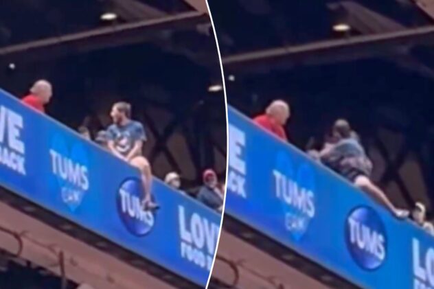 Cardinals fan dangerously hangs off upper deck ledge in terrifying scene