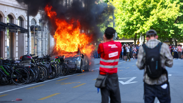 Anti-G7 protest turns violent as demonstrators torch Tesla and smash UN office windows